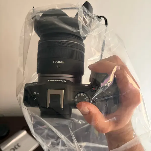 Verified buyer's Canon camera wearing the clear Rainskin rain cover in heavy rain