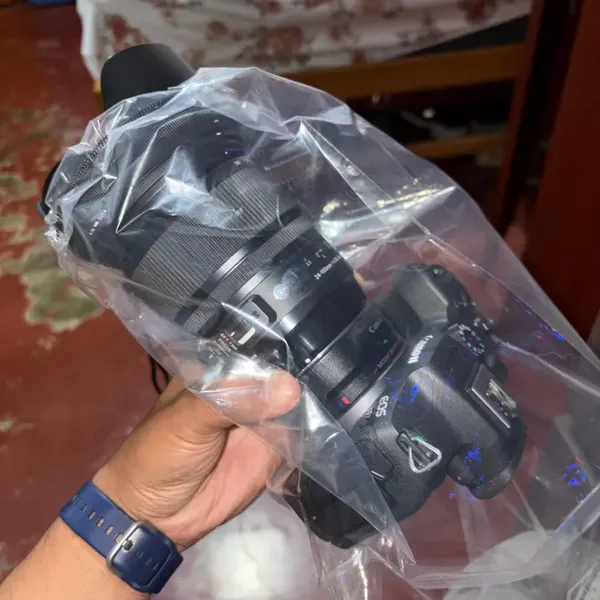 Clear camera rain cover fitted over a mirrorless body, verified buyer photo